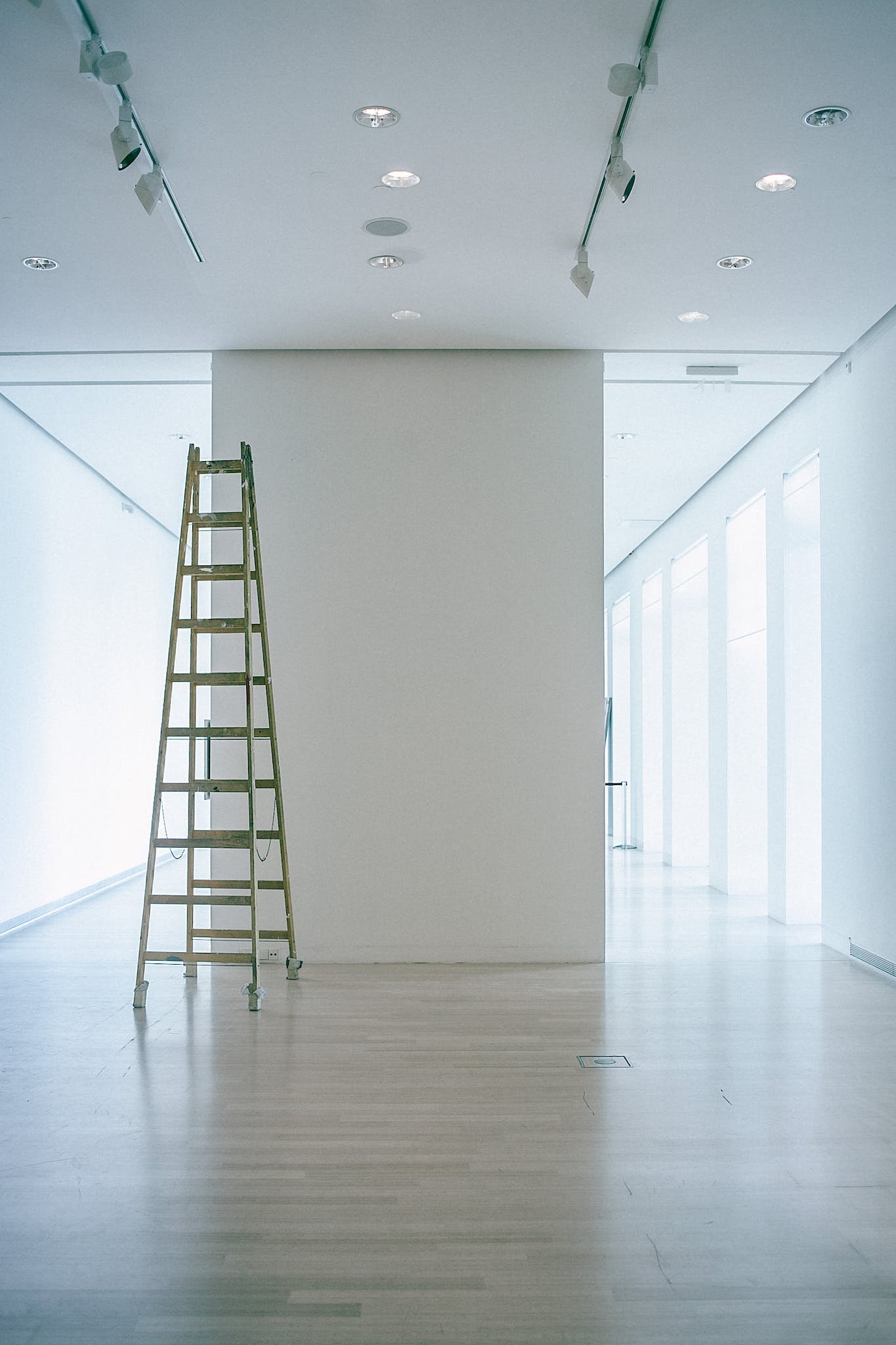 Empty corridor with ladder and lamps on ceiling